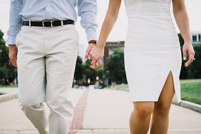 Kráčajúci muž a žena držiaci sa za ruku